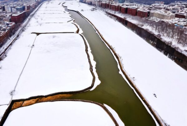 Aerial view of snow-covered cityscape with river.