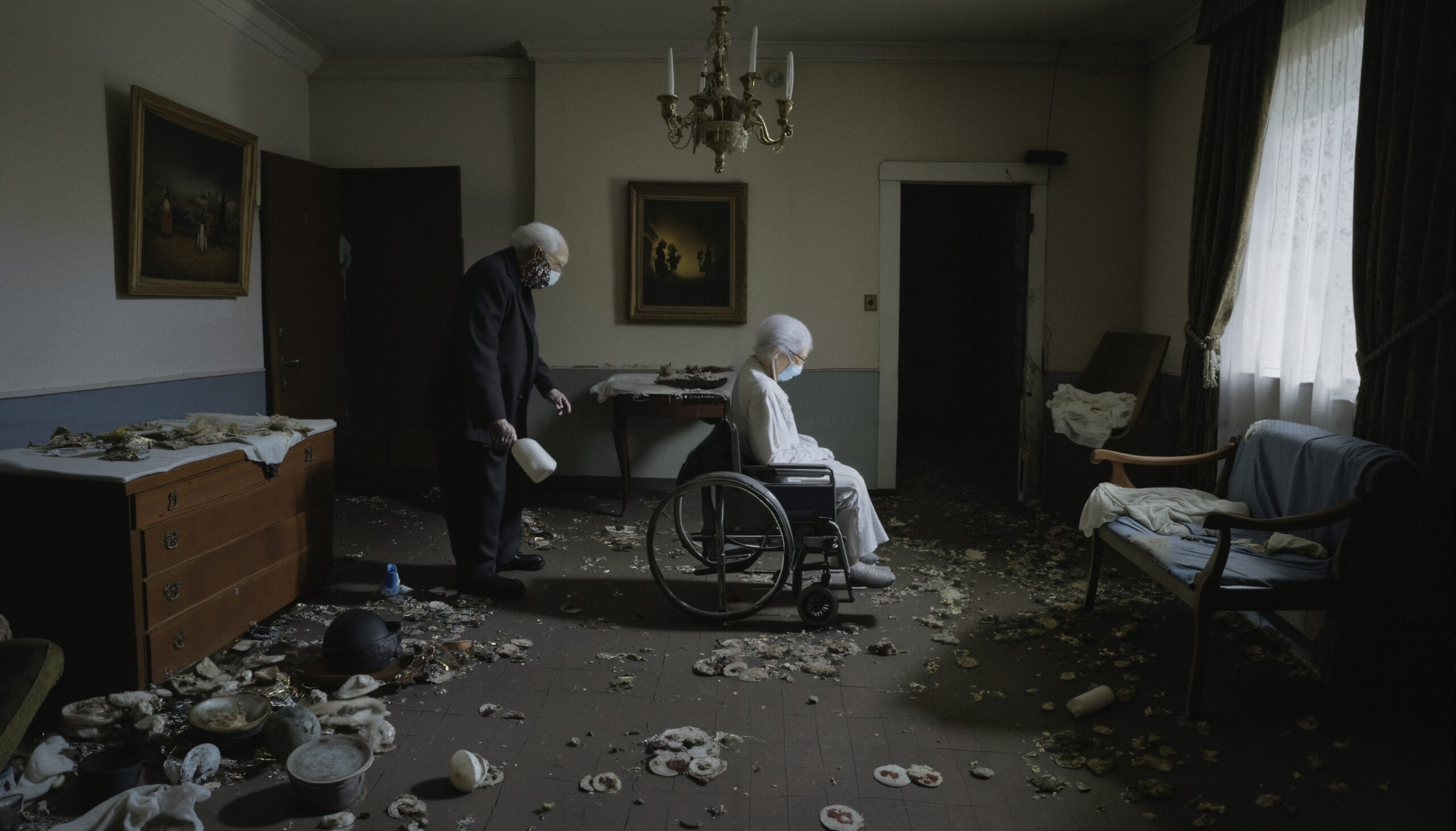 Dilapidated room with elderly pair