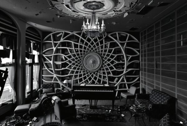 Abandoned room with elegant piano and chandelier.