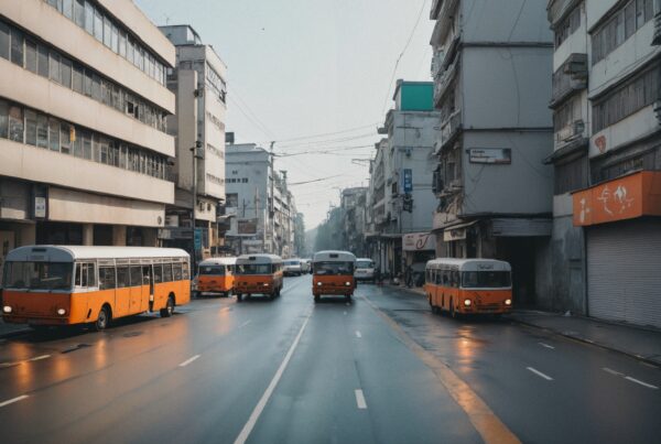 Vintage orange and white buses parked on a quiet street.