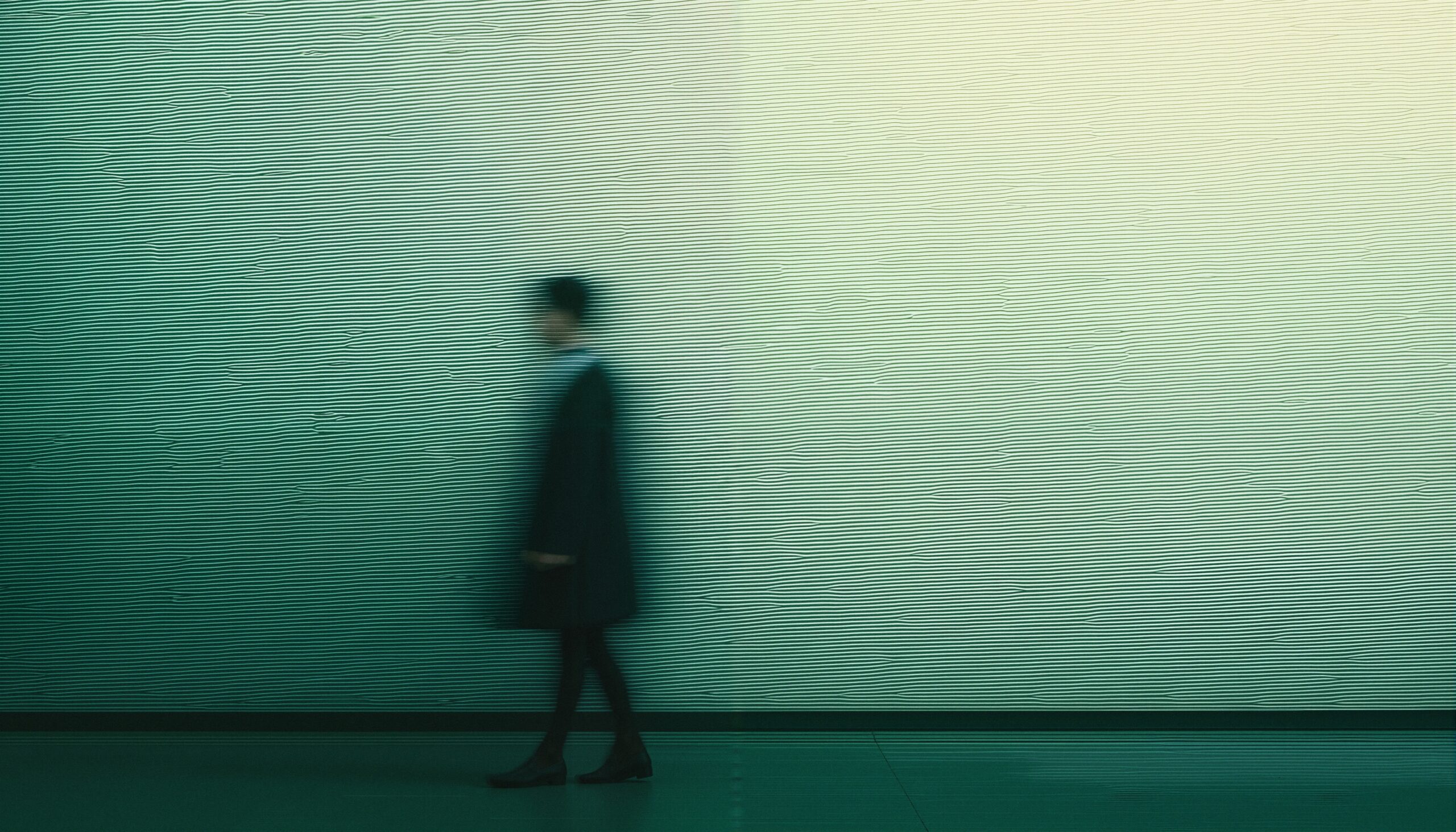 Blurred Figure Against Textured Wall