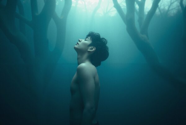 A serene, contemplative underwater scene featuring a young man surrounded by ethereal light and abstract structures.