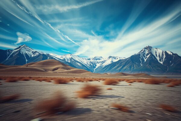 Majestic snow-covered mountains behind desert.