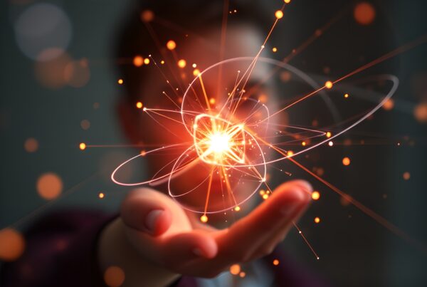 A person holding a glowing, atomic-like structure emitting bright orange light, with a blurred background.