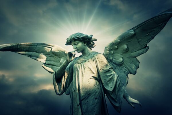 4K video loop of a statue of angel with wings, glowing time-lapse sky background.