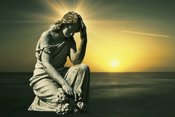 4K video of a serene statue on a golden time-lapse sunset over ocean evoking tranquility and reflection.