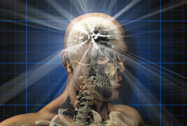 Video animation loop of a human head revealing internal anatomy with glowing brain beams against a grid background, symbolizing the fusion of technology and biological science.