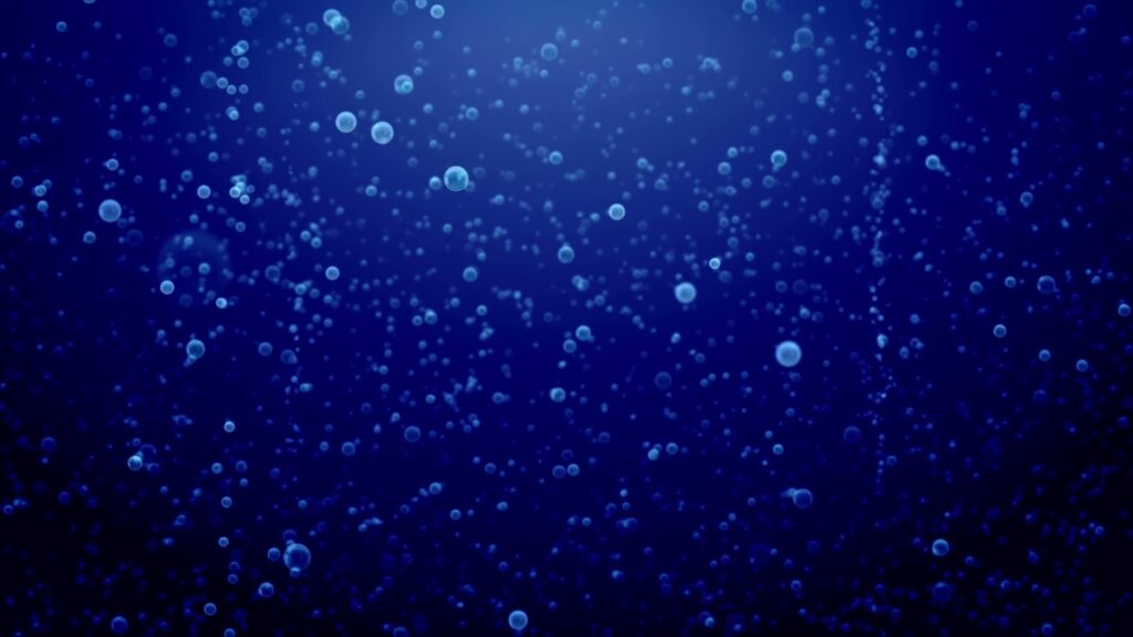Underwater video loop with countless small bubbles rising through a deep blue background, creating a serene and ethereal atmosphere.