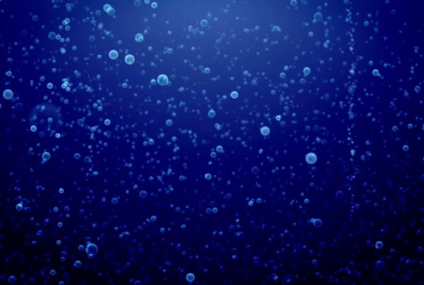 Underwater video loop with countless small bubbles rising through a deep blue background, creating a serene and ethereal atmosphere.