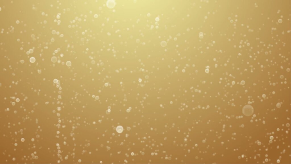 Dreamy golden background with delicate bokeh champaign bubbles rising, creating an elegant and sophisticated atmosphere of celebration.