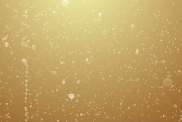 Dreamy golden background with delicate bokeh champaign bubbles rising, creating an elegant and sophisticated atmosphere of celebration.