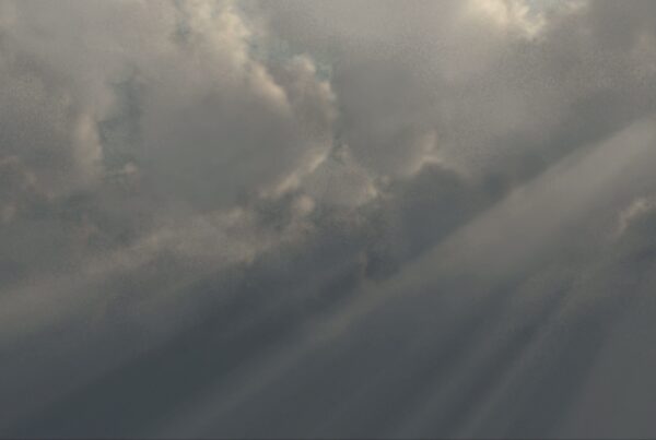 A 4K video loop of a dramatic sky with thick clouds and sunbeams creating a striking contrast, capturing the dynamic interplay of light and shadow.