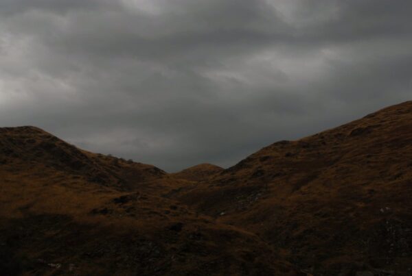 An atmospheric video of rugged, brown hills under a time-lapse, overcast sky, showcasing the stark beauty and desolate charm of the mountainous landscape.