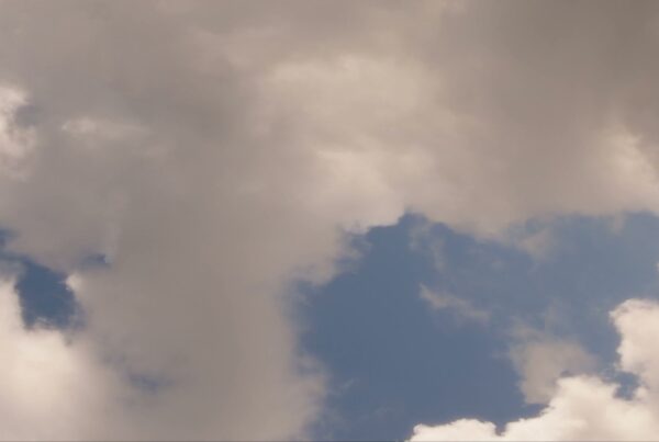 Fluffy white and gray time-lapse clouds against a blue sky, capturing a serene and tranquil atmosphere.