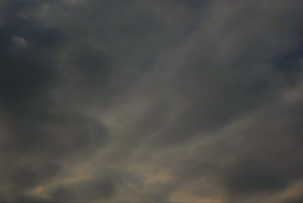 Dark and dramatic overcast sky with dense, layered time-lapse clouds creating an ominous and moody atmosphere, suggesting an approaching storm or evening weather change.