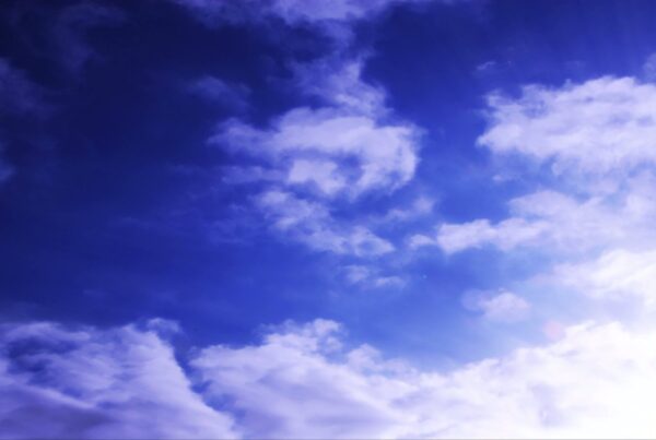 A tranquil video of a blue sky with wispy time-lapse clouds and sunlight casting a serene atmosphere.