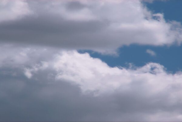 A captivating view of dynamic time-lapse clouds set against a vibrant blue sky, showcasing contrasting light and dark areas, emphasizing the beauty and complexity of natural weather patterns.