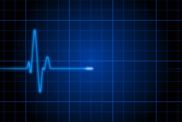 Video oop of a blue ECG heartbeat line on a dark grid background, representing a medical heart monitor and healthcare technology themes.