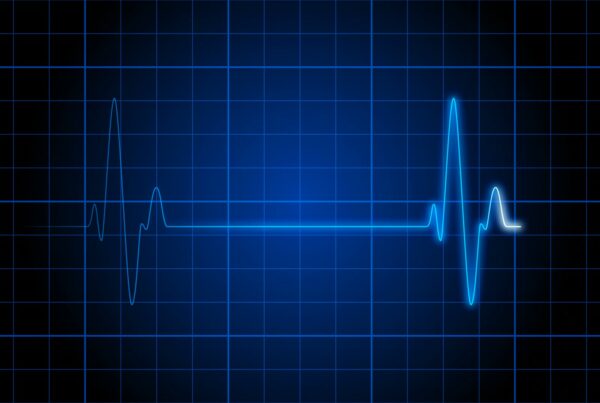 Bright blue animating ECG line fluctuating on a blue grid background, illustrating heart rhythm and medical monitoring.
