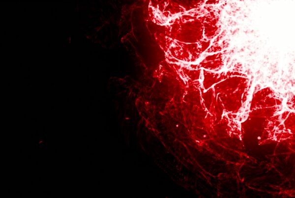 Abstract video loop showcasing a dynamic burst of red and white energy with intricate patterns against a dark background, resembling a fiery explosion.