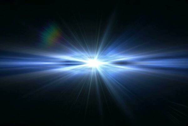 A stunning looping video of a bright, blue-white burst of light radiating symmetrically from the center against a dark background, with a subtle rainbow flare on the upper left.