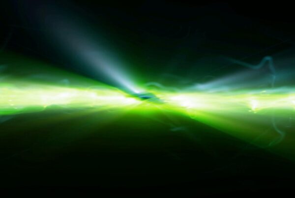 Abstract HD video loop of vibrant green and yellow light streaks bursting outward, creating dynamic energy in a dark, cosmic video background.