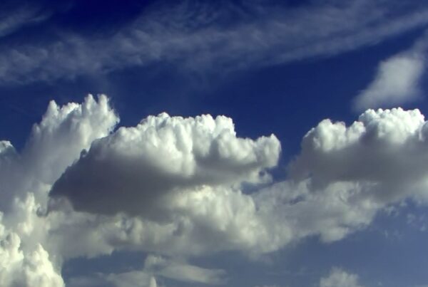 A blue sky with turbulent time-lapse white clouds.
