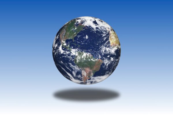 Digital 3D animation loop of a rotating Earth against a gradient blue background, featuring continents and oceans with a prominent shadow effect.