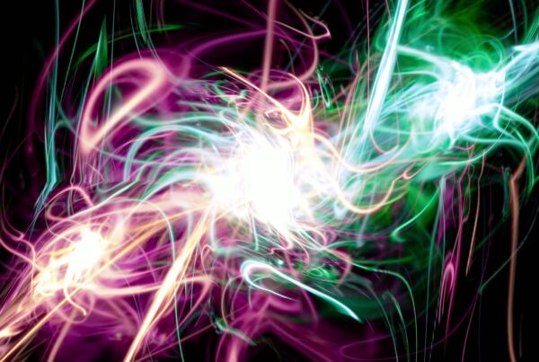 Abstract video loop featuring a vibrant swirl of pink, green, and blue lights spiraling around a bright white burst, set against a dark background, evoking a dynamic and energetic explosion of color.