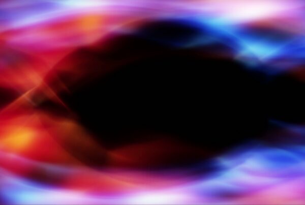Abstract video background loop of mesmerizing light swirls with vibrant colors and dark center.