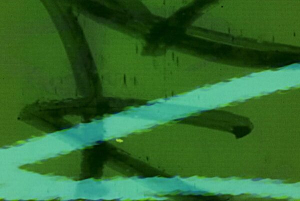 Looping video of vintage 16mm film leader with scratches, dust, hand-drawn markings, and cyan light streaks on a green background.