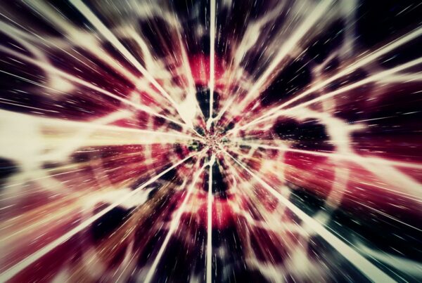 Abstract video loop animation of a cosmic explosion with streaking colors and light, showing high-speed travel through space.