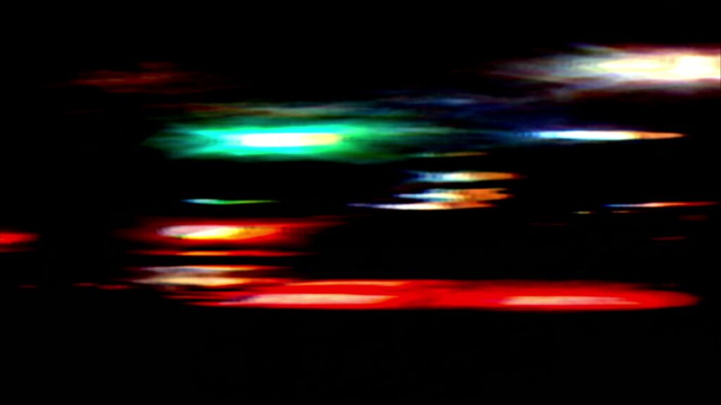 Vibrant video loop of abstract streaks of colorful city lights against a dark background.