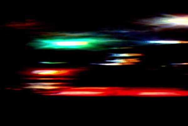 Vibrant video loop of abstract streaks of colorful city lights against a dark background.