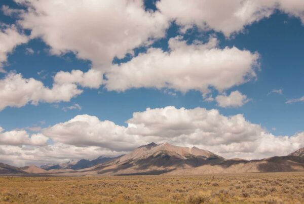 The video captures a breathtaking time-lapse landscape of a vast valley with majestic mountains in the background.