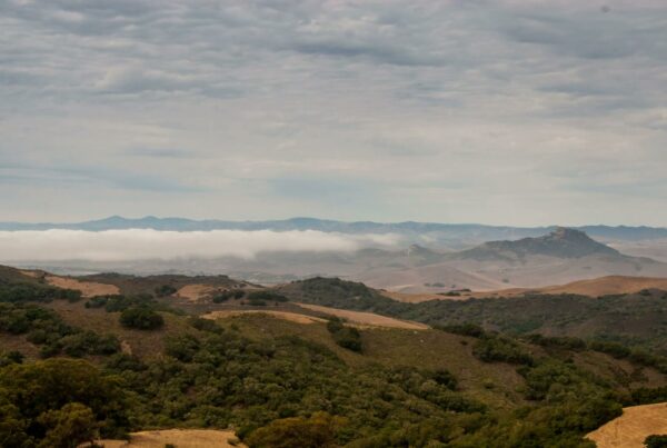 The video depicts a scenic time-lapse landscape with rolling hills stretching into the distance.