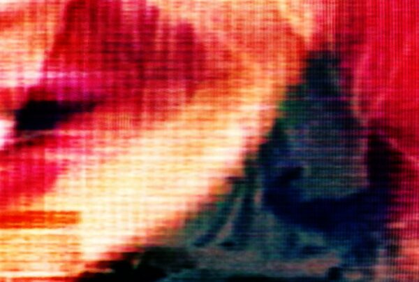 A vibrant and abstract close-up video loop of a pixelated digital screen, showcasing vivid red, orange, and yellow hues with visible pixels creating a mysterious and dynamic effect.