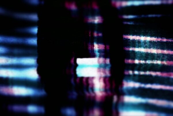 Abstract digital glitch art video loop with vibrant blues, pinks, and whites forming distorted lines on a dark background, evoking technology breakdown.