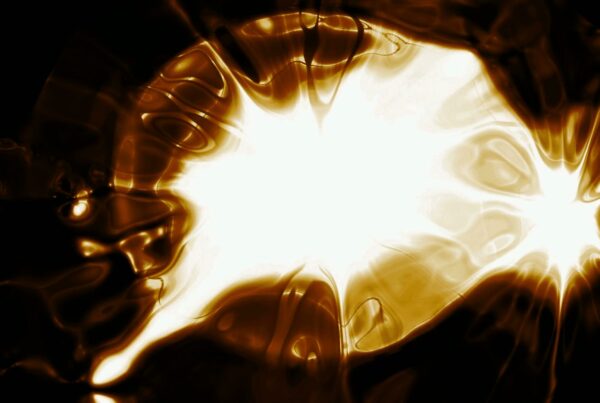 Abstract video loop with a radiant golden light burst at the center, surrounded by swirling patterns and dark contrasting areas, showing an impression of energy in motion.