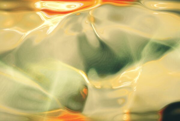 Abstract 4K video loop with swirling gold and green hues and a liquid-like appearance.