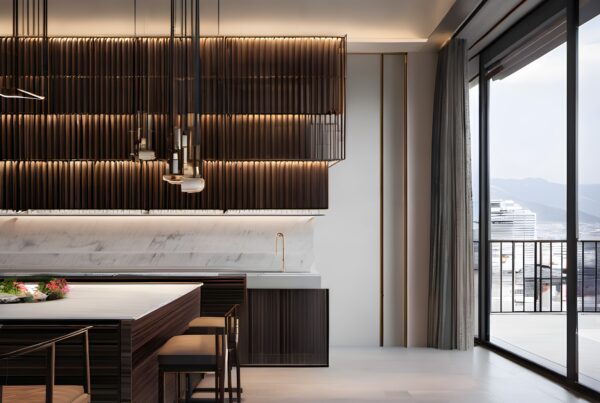 Modern kitchen with marble countertop, pendant lighting, sleek cabinets, and city view.