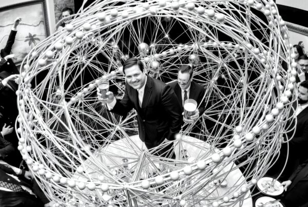Elegant social gathering featuring a central wire sculpture with smiling attendees.