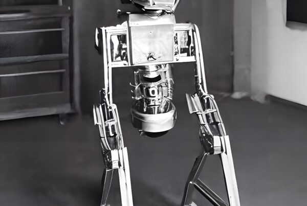 A futuristic metal humanoid robot standing in a workshop.