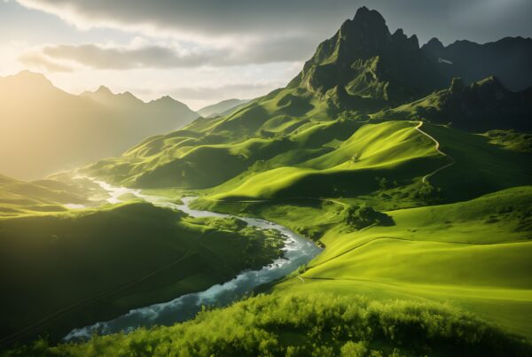 A stunning landscape of green hills and mountains at sunrise with a winding river.