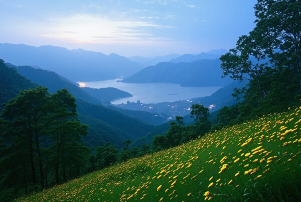 A tranquil mountain landscape at dusk with yellow wildflowers and a lake.
