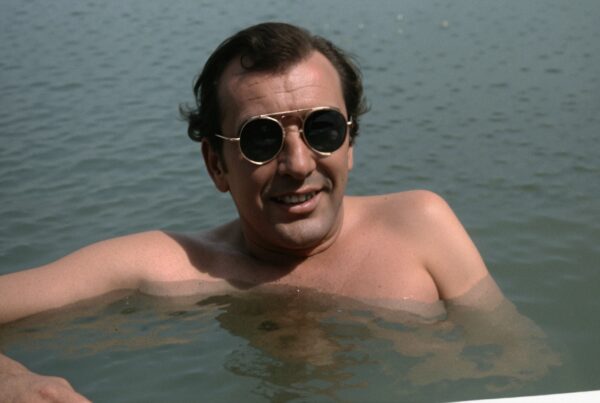 A man with sunglasses relaxes in a tranquil body of water.