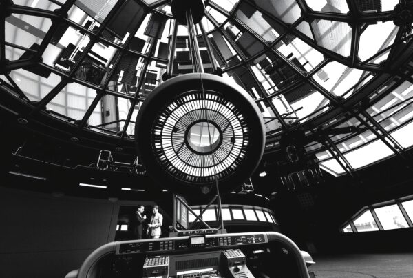 Intricate circular structure under glass dome ceiling.