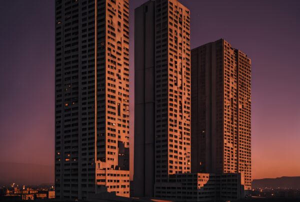 Detailed view of skyscrapers against a purple and orange sunset sky.