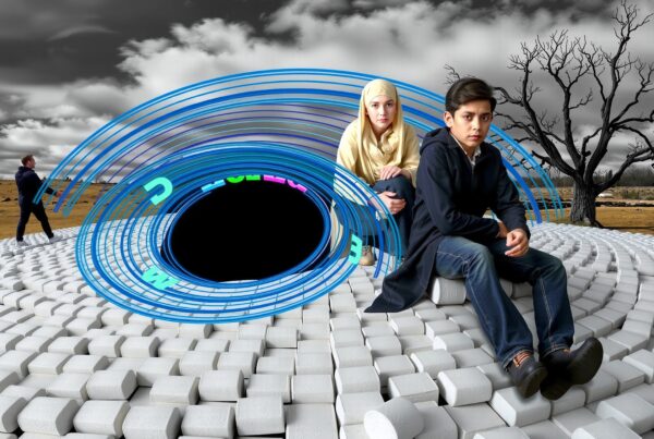 A young boy and woman sit on a white spiral structure in a barren landscape with a surreal design and a leafless tree.
