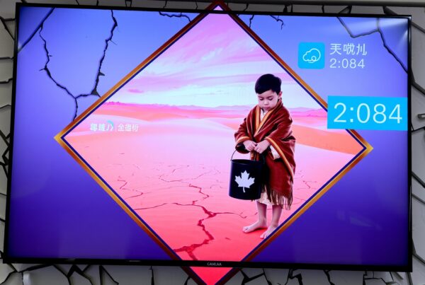 A colorful TV display shows a child holding a bucket in a surreal desert scene.